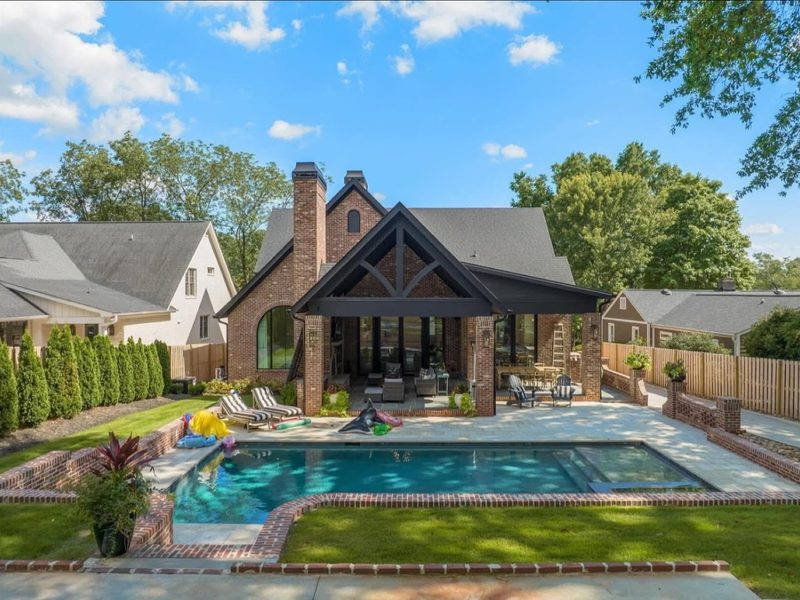 Brick home with a covered patio and pool